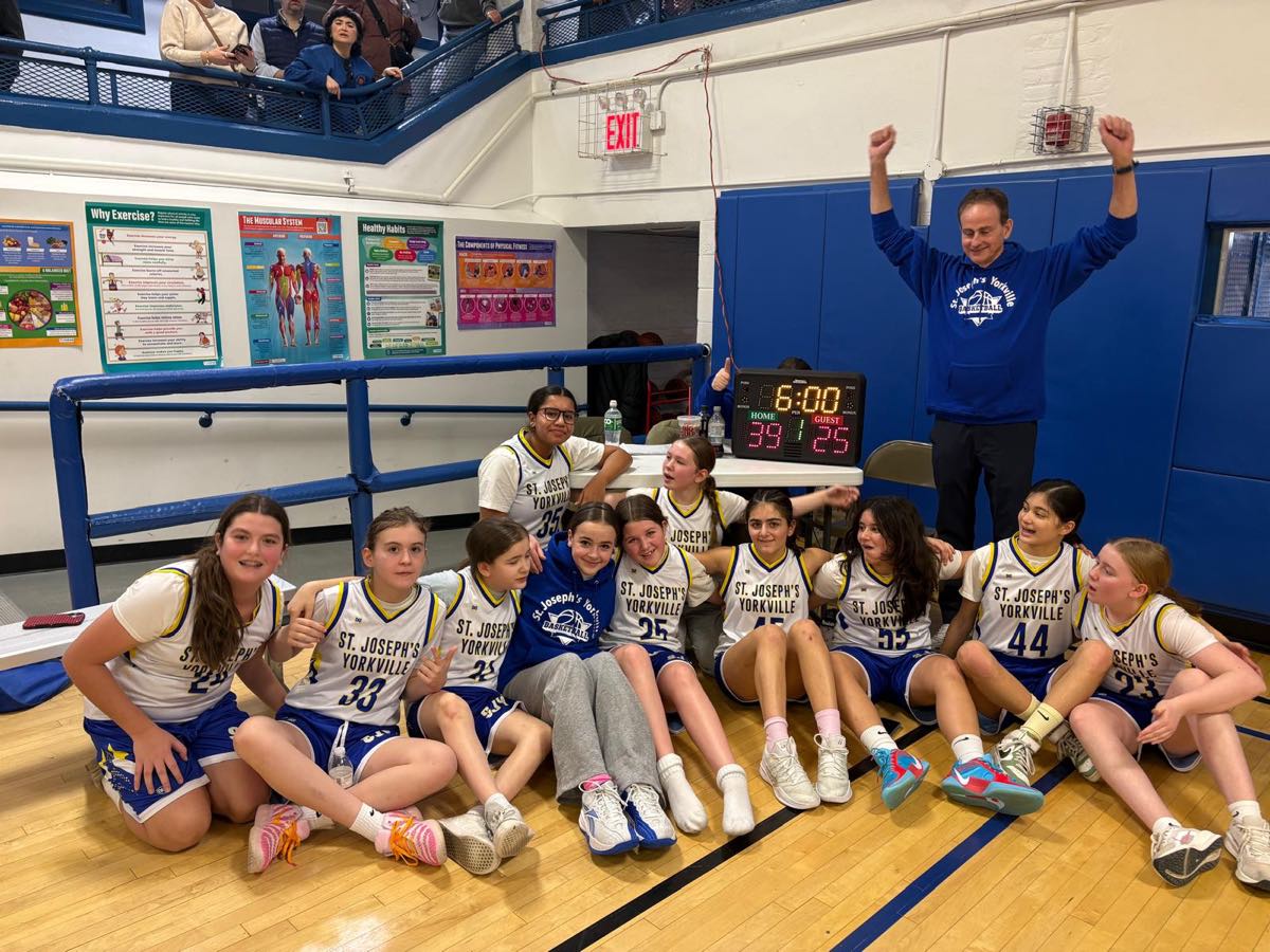 A St. Joseph's Yorkville CYO girls' team celebrating a win with their volunteer coach.